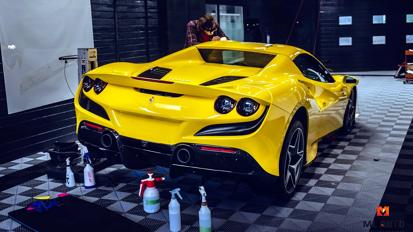 Geltonas sportinis automobilis ML AUTO studijoje, šalia valymo priemonės